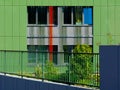 Green glass office building facade detail with windows. lush summer garden.