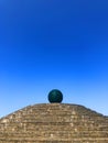 Green glass sphere on top of a granite step pyramid on the embankment of the Dnieper river, bottom view. Ball of Wishes