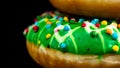 Green glazed donut with sprinkles isolated. Close up of colorful donut Royalty Free Stock Photo