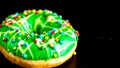 Green glazed donut with sprinkles isolated. Close up of colorful donut Royalty Free Stock Photo