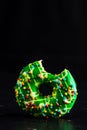 Green glazed donut with sprinkles isolated. Close up of colorful bitten donut Royalty Free Stock Photo