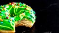 Green glazed donut with sprinkles isolated. Close up of colorful bitten donut Royalty Free Stock Photo