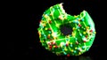 Green glazed donut with sprinkles isolated. Close up of colorful bitten donut Royalty Free Stock Photo