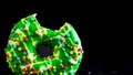 Green glazed donut with sprinkles isolated. Close up of colorful bitten donut Royalty Free Stock Photo