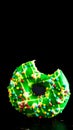 Green glazed donut with sprinkles isolated. Close up of colorful bitten donut Royalty Free Stock Photo