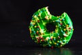 Green glazed donut with sprinkles isolated. Close up of colorful bitten donut Royalty Free Stock Photo