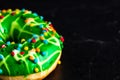 Green glazed donut with sprinkles isolated. Close up of colorful donut Royalty Free Stock Photo