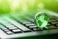 Green globe on a laptop keyboard with green bokeh background Royalty Free Stock Photo