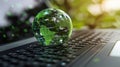 Green Globe On Laptop Keyboard: Sustainability Concept Royalty Free Stock Photo