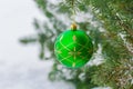 Green with gold ornament christmas bauble hanging on a spruce branch Royalty Free Stock Photo