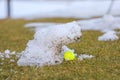 Green golf ball on cloudy snow covered golf course