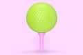 Green golf ball on tee isolated on pink background Royalty Free Stock Photo