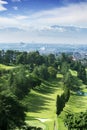 Green golf course with misty Bandung cityscape