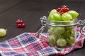 Green gooseberries in glass jar and on napkin Royalty Free Stock Photo