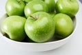 Green Granny Smith cooking apples in a white bowl close-up from above. Royalty Free Stock Photo