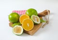 Green grapefruits and halved orange