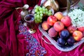 Green grapes, plums, peaches, nectarines, jugs, a glass of wine, white hydrangea, a Dutch still life on a silk tablecloth, with