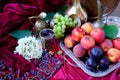 Green grapes, plums, peaches, nectarines, jugs, a glass of wine, white hydrangea, a Dutch still life on a silk tablecloth, with