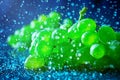 Green grapes in splashes on blue background