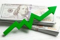 Green graphic arrow up and stack of cash. Profit and performance growth. Royalty Free Stock Photo