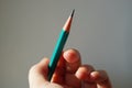 Green graphite pencil in human hand with sunlight Royalty Free Stock Photo