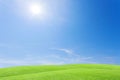 Green grass field and beautiful blue sky with clouds background.