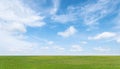 Green grass field and blue sky with white clouds. Beautiful landscape background Royalty Free Stock Photo