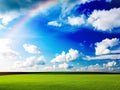 Green Grass Field Blue white clouds sky and rainbow nature summer landscape background Royalty Free Stock Photo