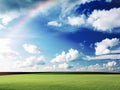 Green Grass Field Blue white clouds sky and rainbow nature summer landscape background Royalty Free Stock Photo