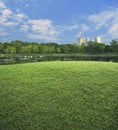 Green grass field with lake and tree in public city park, nature Royalty Free Stock Photo