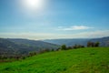 Green grass field on small hills and blue sky with clouds Royalty Free Stock Photo