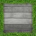 Green grass frame with vintage wooden background. Royalty Free Stock Photo