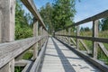 Green grass growing between the planks of a wooden footway Royalty Free Stock Photo