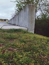 green grass leading onto a concrete sidewalk bridge over a flowing river Royalty Free Stock Photo