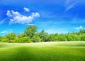 Green grass meadow field and little hill with white clouds and blue sky in summer seasonal. Royalty Free Stock Photo