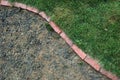 Green grass next to rocks divded by bricks Royalty Free Stock Photo
