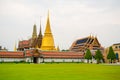 Bangkok, Thailand - January 25, 2016: Green grass outside the Grand Palace in Bangkok with stupas and temple roofs behind Royalty Free Stock Photo