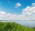 Green grass, river and clouds in blue sky Royalty Free Stock Photo