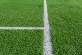 Green grass and white border lines on football ground.