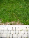 Green grass and white, grey pavements. Handmade and nature