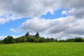 Green grassfield with medieval castle ruins Royalty Free Stock Photo