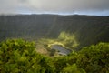 A green grassy bottom of an extinct crater with a small lake on the island Royalty Free Stock Photo