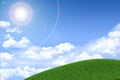 Green grassy hill. Background clouds and sun Royalty Free Stock Photo