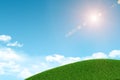 Green grassy hill. Background clouds and sun Royalty Free Stock Photo