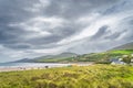 Green grassy meadow or dunes and people walking on Inch Beach