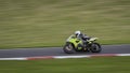 A green/grey racing bike speeding round corners Royalty Free Stock Photo