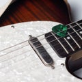 Green Guitar Pick Held in Place by Guitar Strings Royalty Free Stock Photo