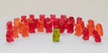 green gummy bear speaking in front of group in red Royalty Free Stock Photo
