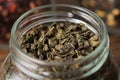 Green gunpowder tea. Green tea leaves in an open glass jar for storing tea Royalty Free Stock Photo