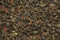 Green gunpowder tea texture. Green tea leaves background. Green tea with safflower flower petals